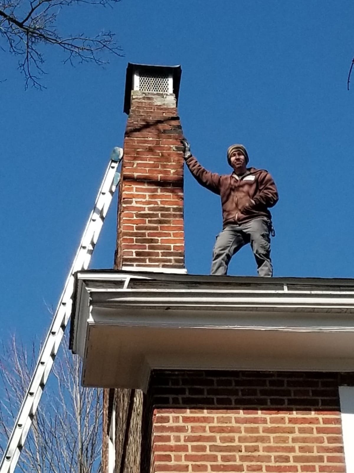 Guardian technician installing a chimney cap and screening on a South Jersey roof